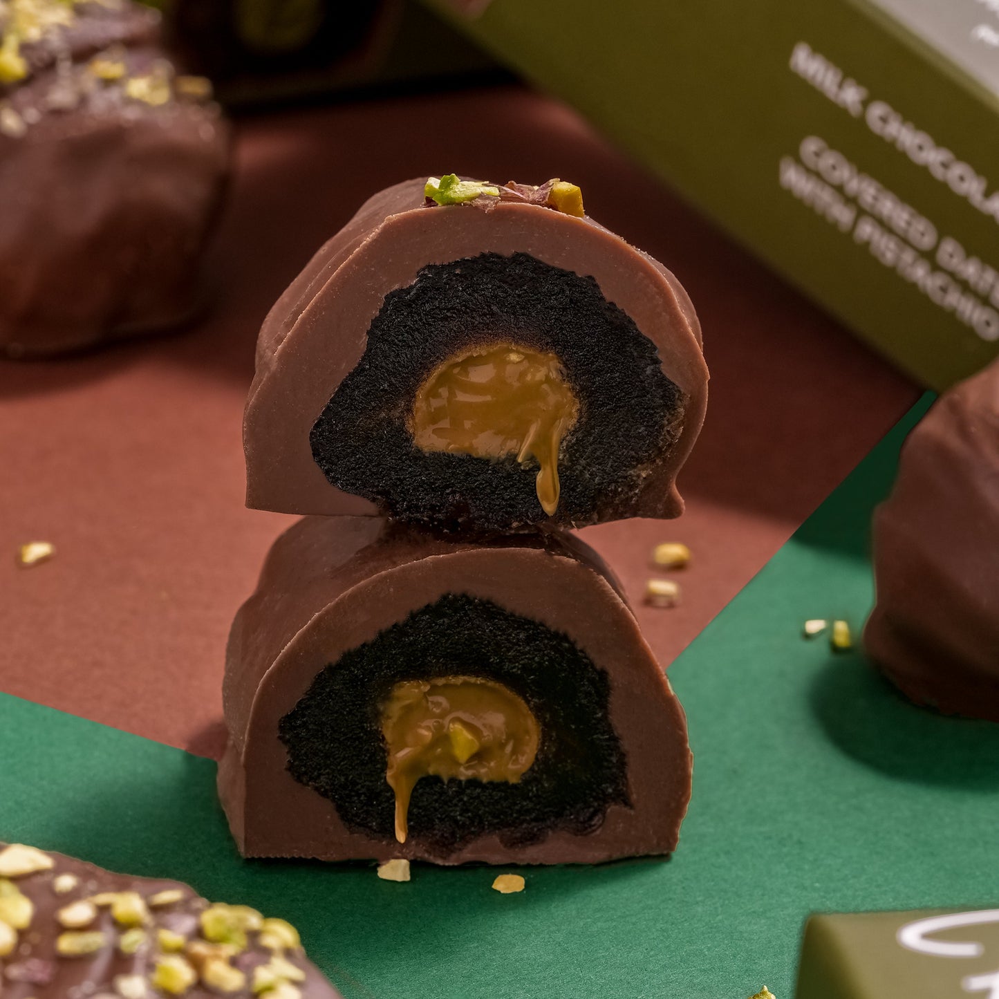Chocolate covered treats with a creamy center on a green surface, surrounded by boxes.