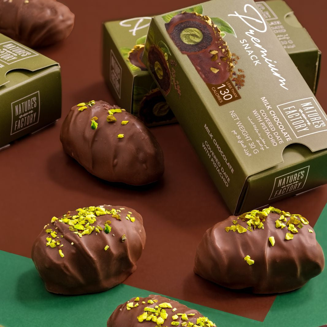 Pistachio Chocolate covered dates surrounded by premium packaging.