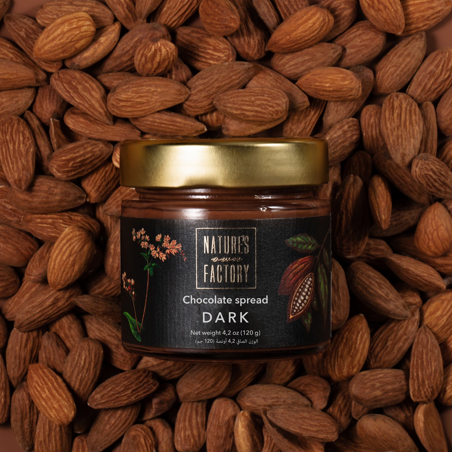 Nature’s Own Factory Dark Chocolate Spread jar placed on a bed of almonds nuts. Natural, handcrafted chocolate spread made in the UAE.